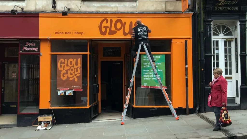 Traditional signwriter Josh Monk paints the GlouGlou branding on the Castle Gates shopfront